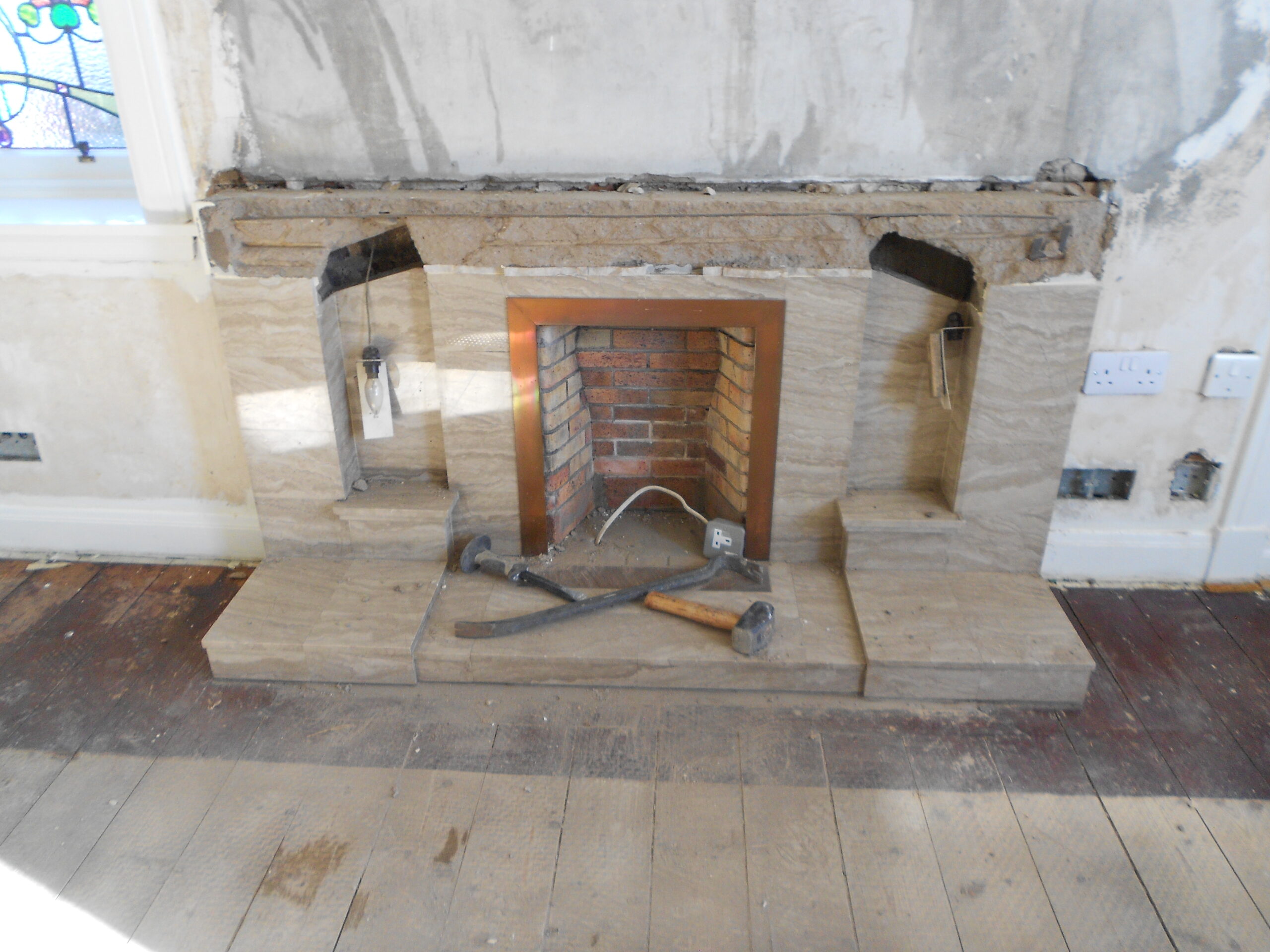 fireplace before removal showing tools in front